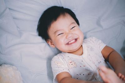 High angle view of baby girl lying on bed at home