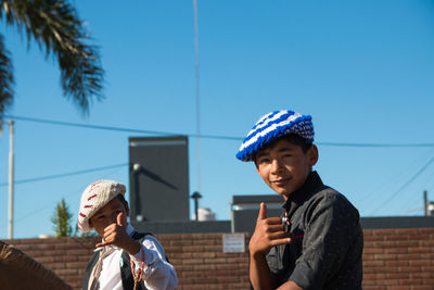 Portrait of boy against blue sky