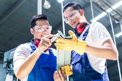 Smiling men working in factory