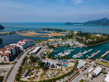 High angle view of city by sea against sky