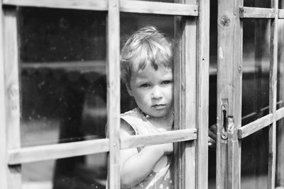 Portrait of cute baby girl looking through window