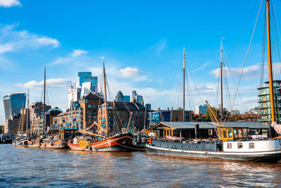 Boats and small ships docked on a river thames in london, uk.