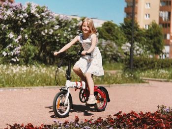 Portrait of young woman riding bicycle on road