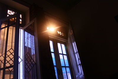 Low angle view of sunlight streaming through window in house