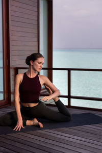Woman exercising on pier