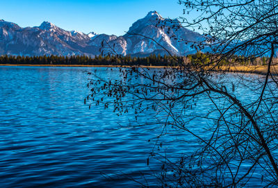 Scenic view of lake and mountains against blue sky