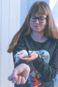 Close-up of smiling girl holding rat