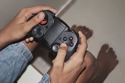 Low section of boy playing video game at home