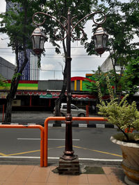 Street light on sidewalk by building in city