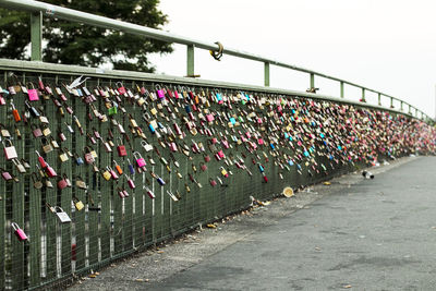Close-up of padlocks on railing against footbridge