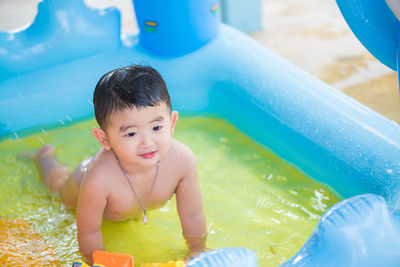 Shirtless baby boy in wading pool