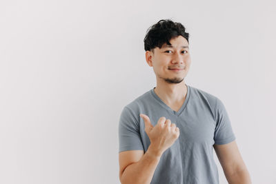 Portrait of smiling young man against white background