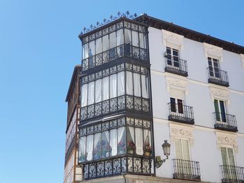 Low angle view of building against clear blue sky. ornamental steel balcony in segovia.