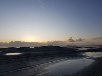 Scenic view of beach against sky during sunset