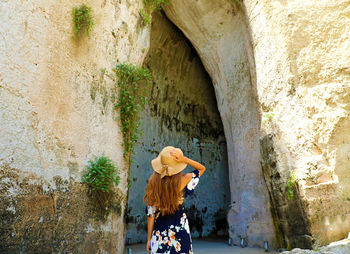 Rear view of woman standing against wall