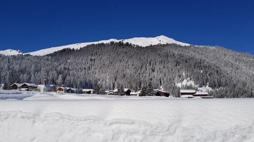 Scenic view of snowcapped mountains against clear blue sky