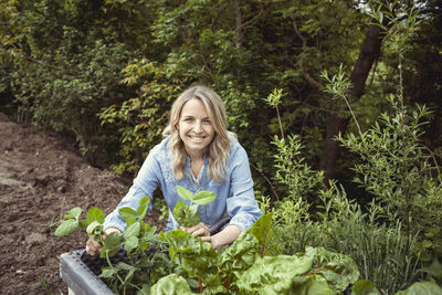 Portrait of smiling woman holding plants