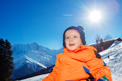 Portrait of smiling boy standing on snow covered mountain