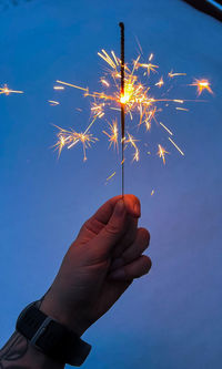 Cropped hand of woman holding illuminated string