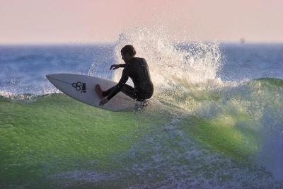 Man surfing on sea against sky