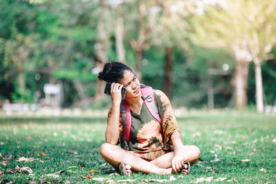 Full length of woman sitting on field