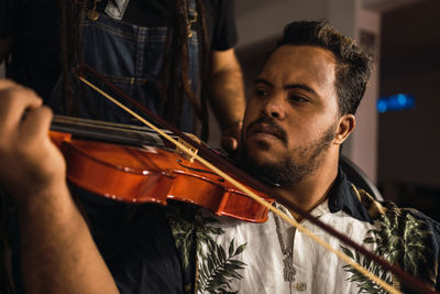 Ethnic man n in casual outfit learning playing violin near cropped unrecognizable tutor