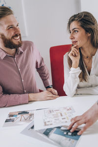 Young couple discussing over document while real estate agent explaining 