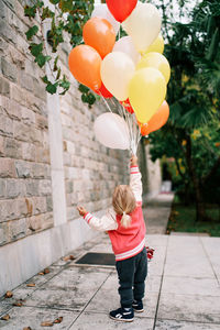 Low section of woman holding balloons