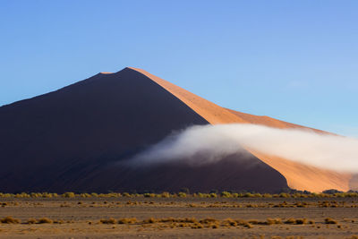 Mountain in desert against clear sky