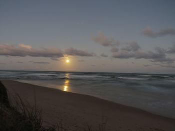 Scenic view of beach against sky during sunset