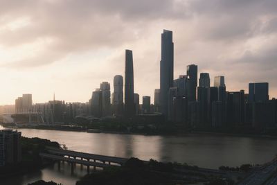 City skyline by river against sky