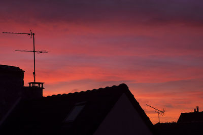 Low angle view of silhouette house against sky during sunset