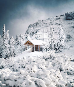 House on snowcapped mountain against sky