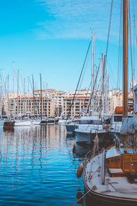 Sailboats moored at harbor