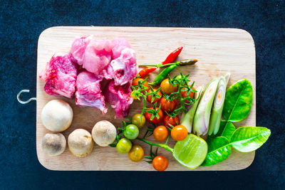 High angle view of raw vegetables along with meat on cutting board