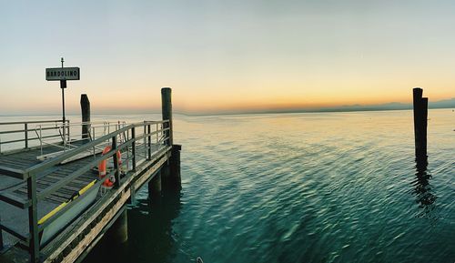 Pier over sea against sky during sunset