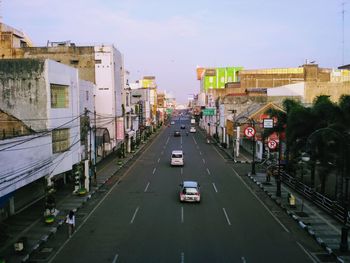 Cars on street in city against sky