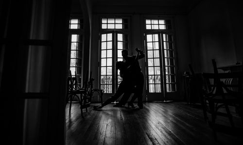 Side view of man standing on table at home