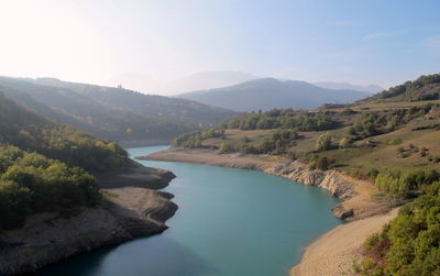 High angle view of river amidst mountains against sky