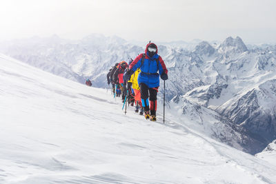 People skiing on snowcapped mountains during winter