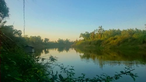 Scenic view of lake against sky at sunset