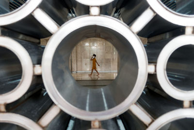 A boy in yellow clothes with medical face mask walks inside the building