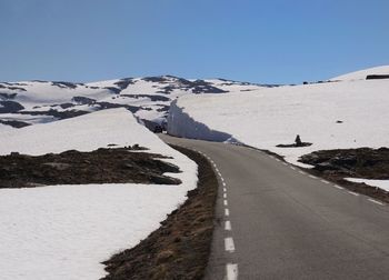 Road amidst landscape against clear blue sky