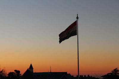 Low angle view of flag against sky during sunset