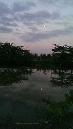 Scenic view of calm lake against cloudy sky