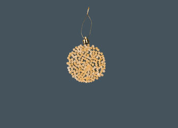 Christmas decoration on a tree in the form of a ball of pasta on a blue paper background, top view.