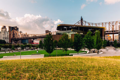 View of bridge in city against cloudy sky