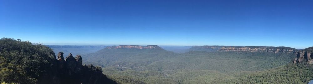 Panoramic view of mountains against clear blue sky