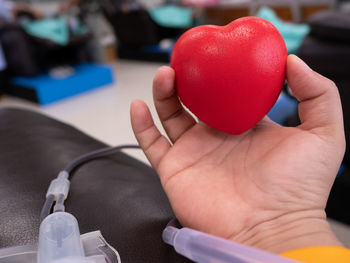Close-up of hand holding strawberry at table