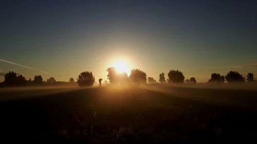 Scenic view of field against clear sky during sunset